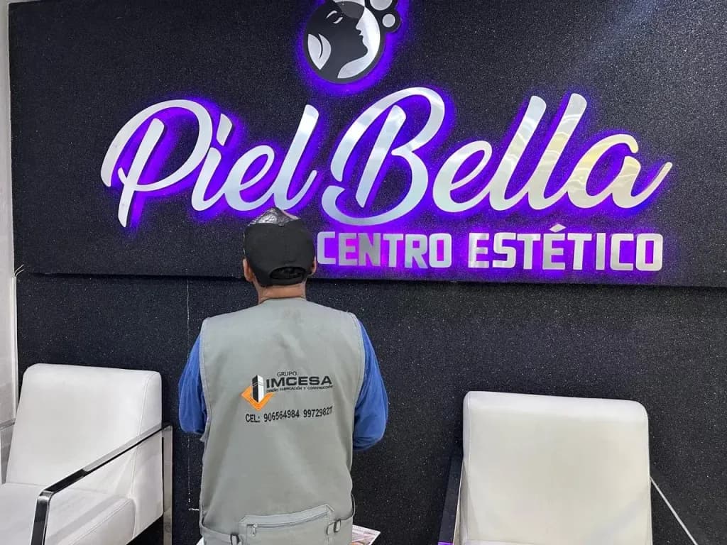 Personal de IMCESA frente al letrero Piel Bella con iluminación violeta