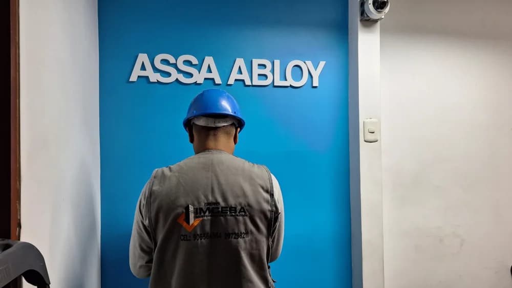 Equipo de Grupo IMCESA instalando un letrero corporativo de ASSA ABLOY